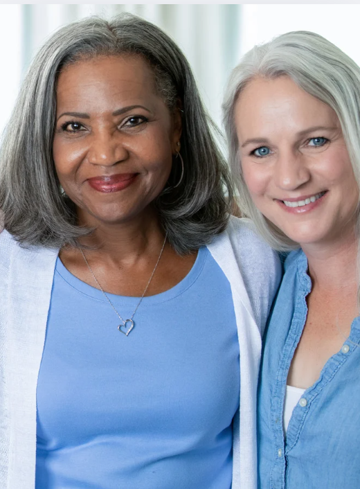 2 middle aged women smiling at the camera