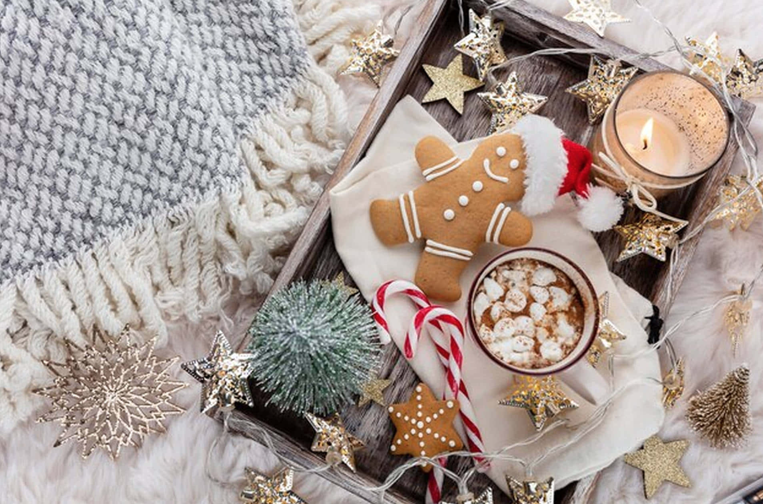Cozy holiday flat lay with gingerbread cookies, cinnamon sticks, and warm Christmas décor representing stress-free holiday planning.
