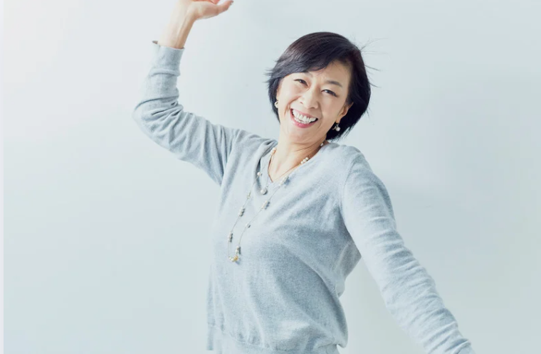 Smiling woman raising her arm joyfully, symbolizing confidence and positivity.