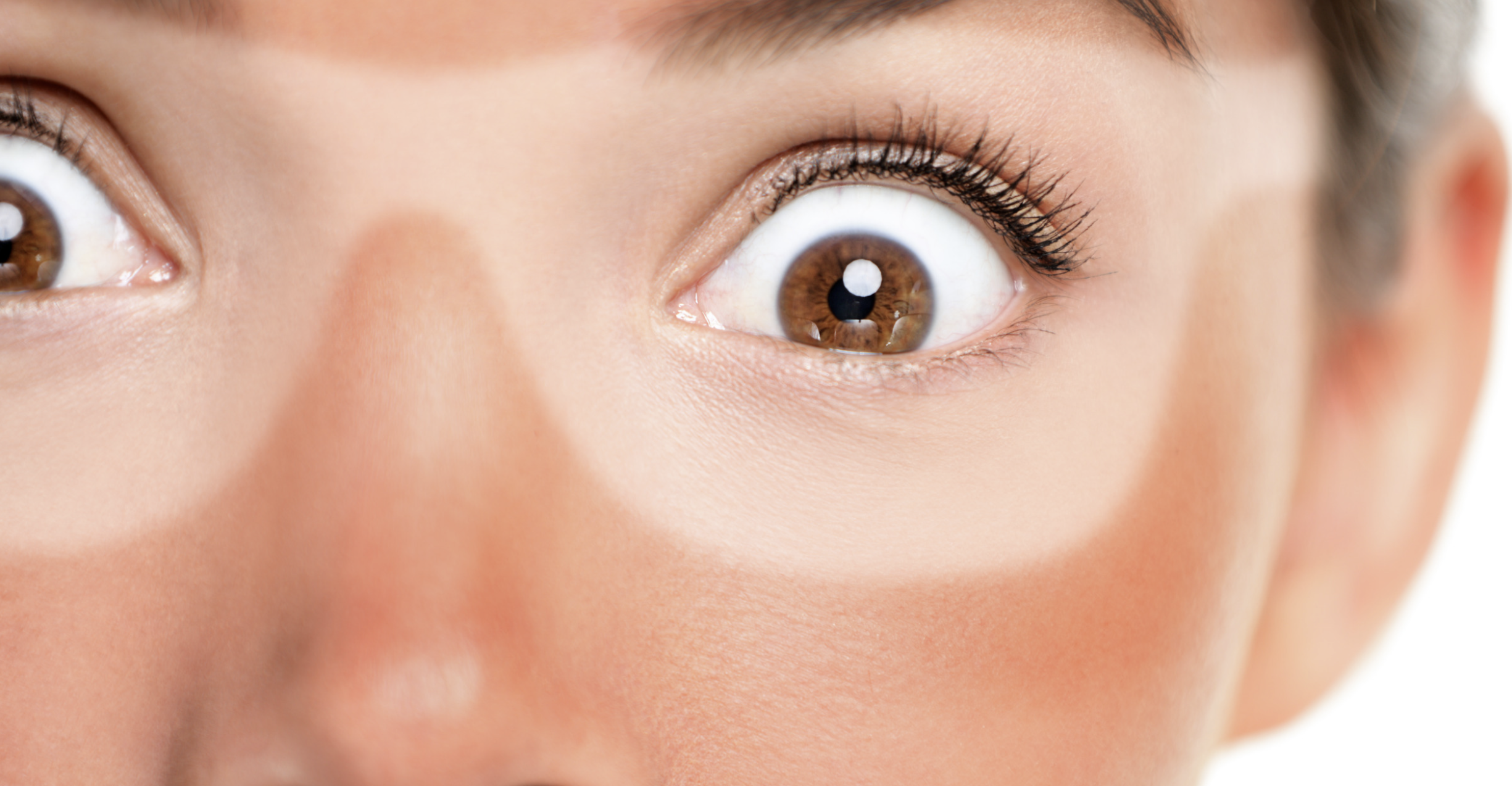 Close-up of surprised eyes representing unexpected skin concerns and skincare challenges during summer