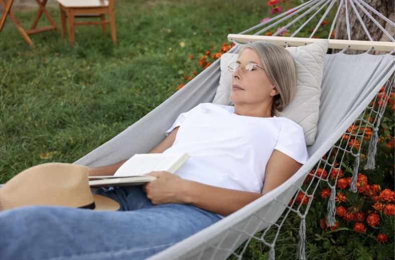 Woman relaxing with a book in a hammock outdoors